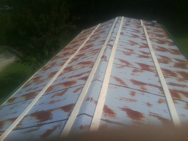 Rusted metal roof panels with new wood purlins before replacement — Storm Damage Roof Repair in Tangent by Roofing Brothers